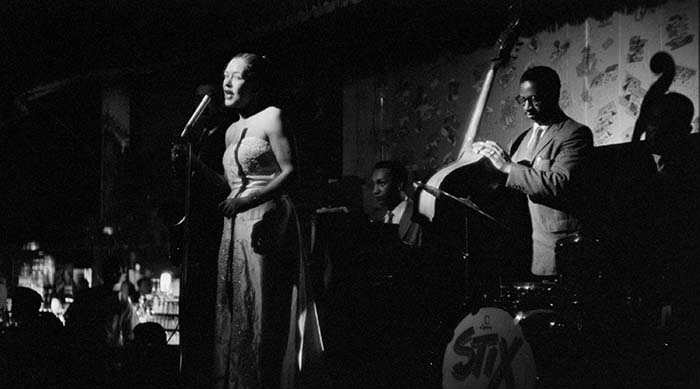 Billie Holiday performing on stage with her band