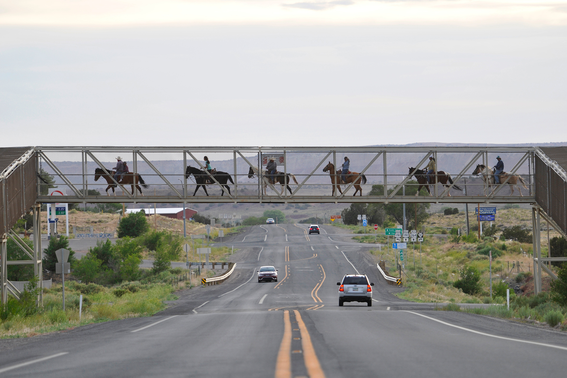 Photograph of family riding horses on an overpass