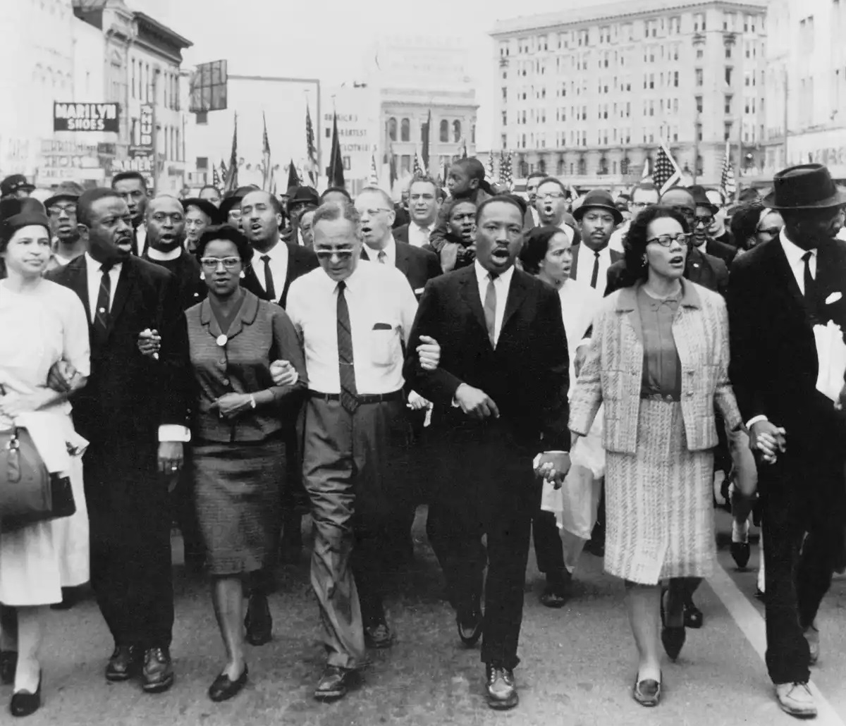 Protestors marching led arm-in-arm by MLK.